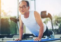 Senior man push up in fitness gym. Mature healthy lifestyle.